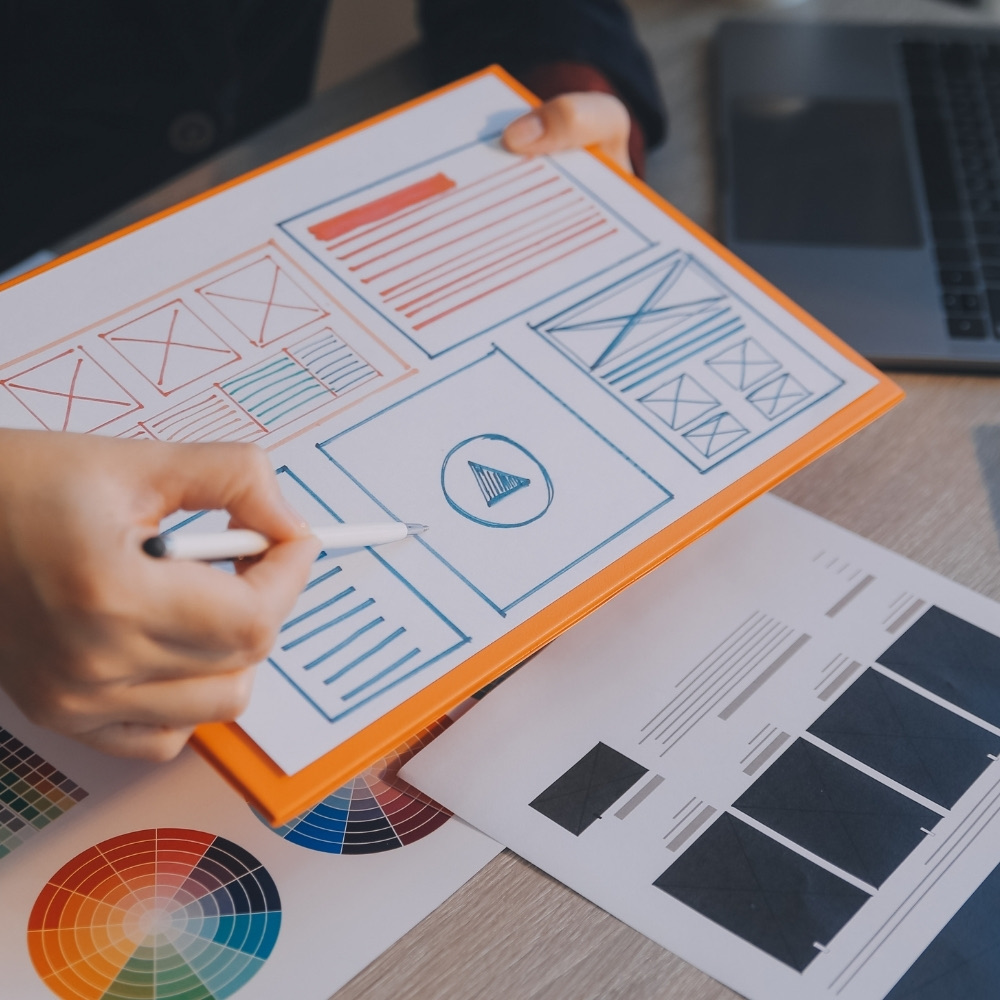 Designer sketching website wireframes on paper